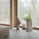 The Ridge Vase from Muuto in off white in a open space.