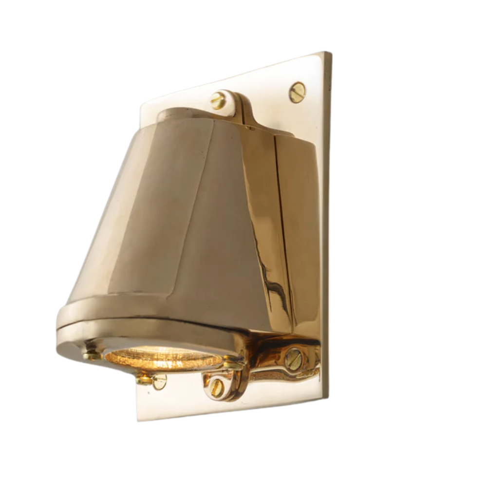 The polished bronze Mast Light Wall Sconce from Original BTC with a plate.
