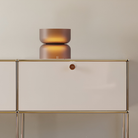 The etched amber Mini Totem Table Lamp from Pablo Designs in a lounge.