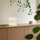 The etched white Mini Totem Table Lamp from Pablo Designs in a living room.