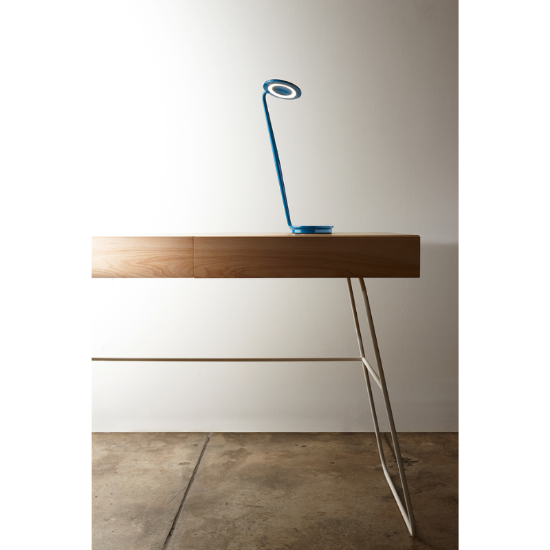 The azure Pixo Plus from Pablo Designs on a desk in a living room.