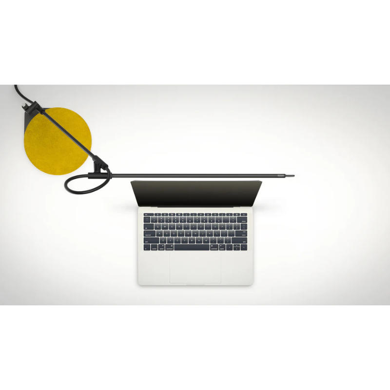 The black Superlight Table Lamp from Pablo Designs in a home office with a laptop.