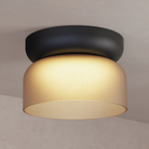 The Totem Mini Flush Mount by Pablo Designs with an etched amber shade and black base in a family area. all-groups