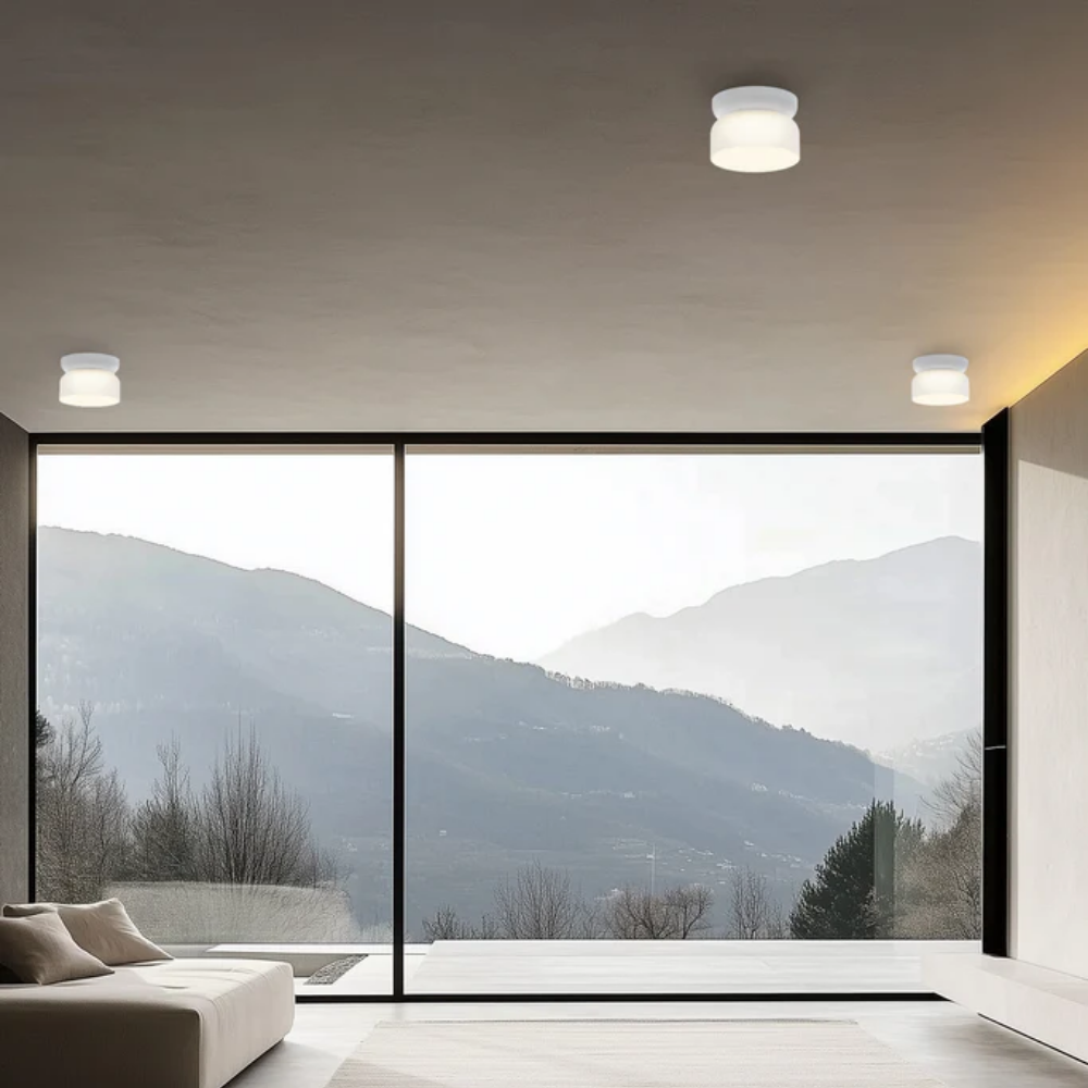 The Totem Mini Flush Mount by Pablo Designs with an etched white shade and white base mount in a modern living room. all-groups
