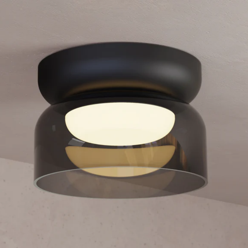 The Totem Mini Flush Mount by Pablo Designs with a smoke shade and black base mount installed on a ceiling. all-groups