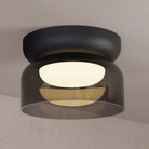 The Totem Mini Flush Mount by Pablo Designs with a smoke shade and black base mount installed on a ceiling. all-groups