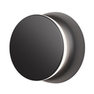 The black and black Totem Puck Ceiling or Wall Light from Pablo Designs turned on, close up.