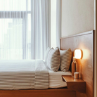 The Dimple Sconce by RBW with White Interior and Natural Anodized installed on a headboard. all-groups
