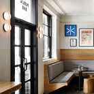 The Dimple Sconce by RBW with White Interior and Black Anodized installed in a restaurant. all-groups