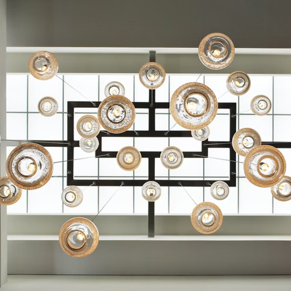 The Bubble Small Orb Clear Pendant from Siemon and Salazar is used in a business space hanging from the ceiling.