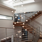 The Bubble Small Orb Clear Pendant from Siemon and Salazar in a living room lighting up a staircase.