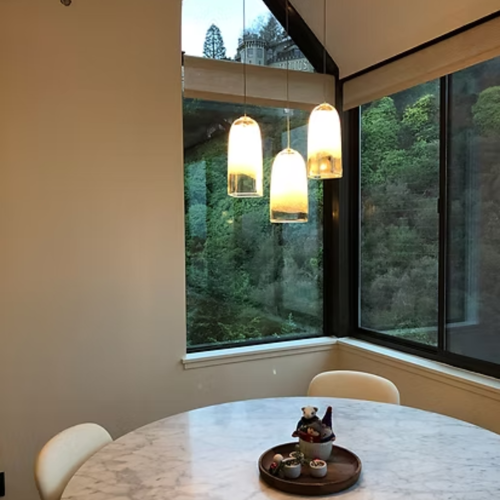 The Bubble Small Square Clear Pendant from Siemon & Salazar in a dining room above a dining table.
