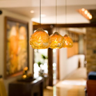 The amber Happy Small Pendant from Siemon and Salazar in a hotel lobby.