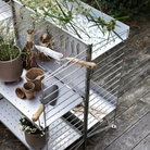 The String Outdoor Bundle from String Furniture being used as garden tool storage.