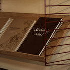 The String System by String Furniture dark red wall panels with oak shelves.