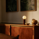 The Shore Table lamp from Tala Lighting in Brown on a credenza.