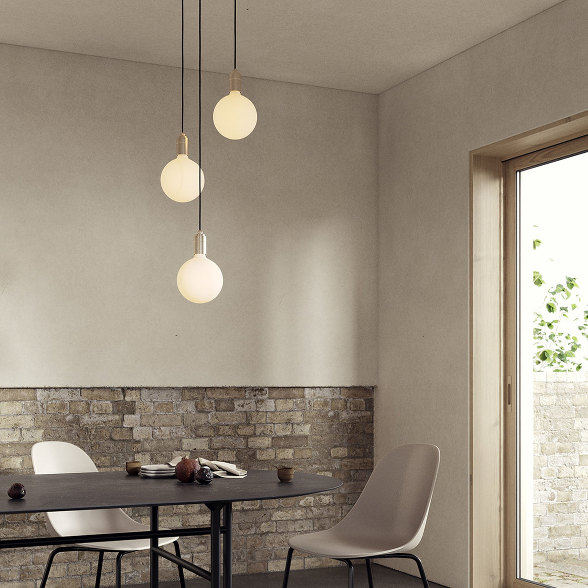 The Triple Pendant in Brass + Sphere IV, three-light fixture by Tala US over a dining table.
