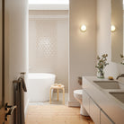 The Firth Wall Light by Tala Lighting on a wall in a bathroom.