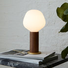 The Enno E26 LED Bulb by Tala Lighting in a walnut table lamp base.