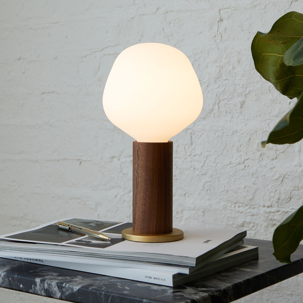 The Enno E26 LED Bulb by Tala Lighting in a walnut table lamp base.