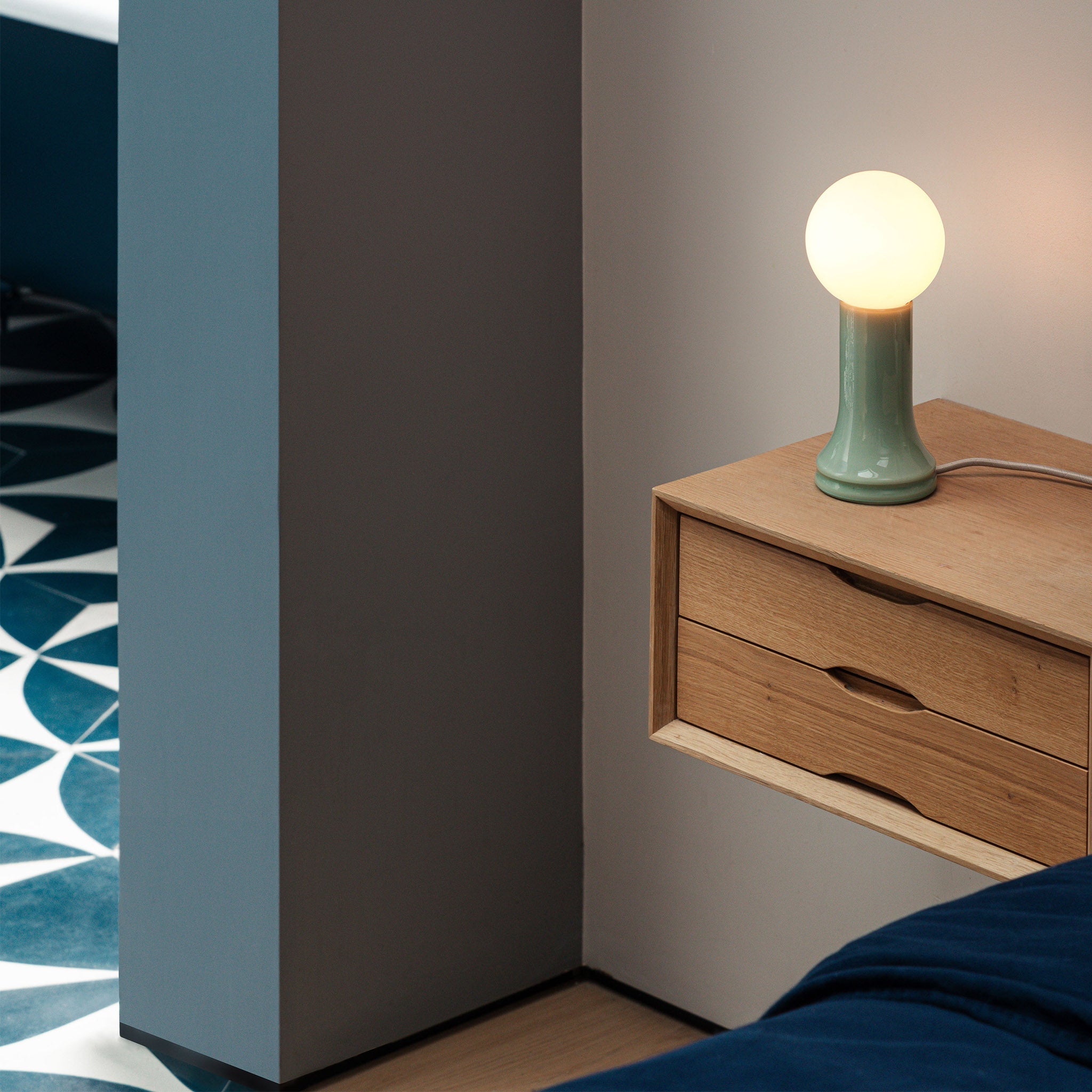 The Shore Table Lamp from Tala Lighting in Sea Green on a bedside table.
