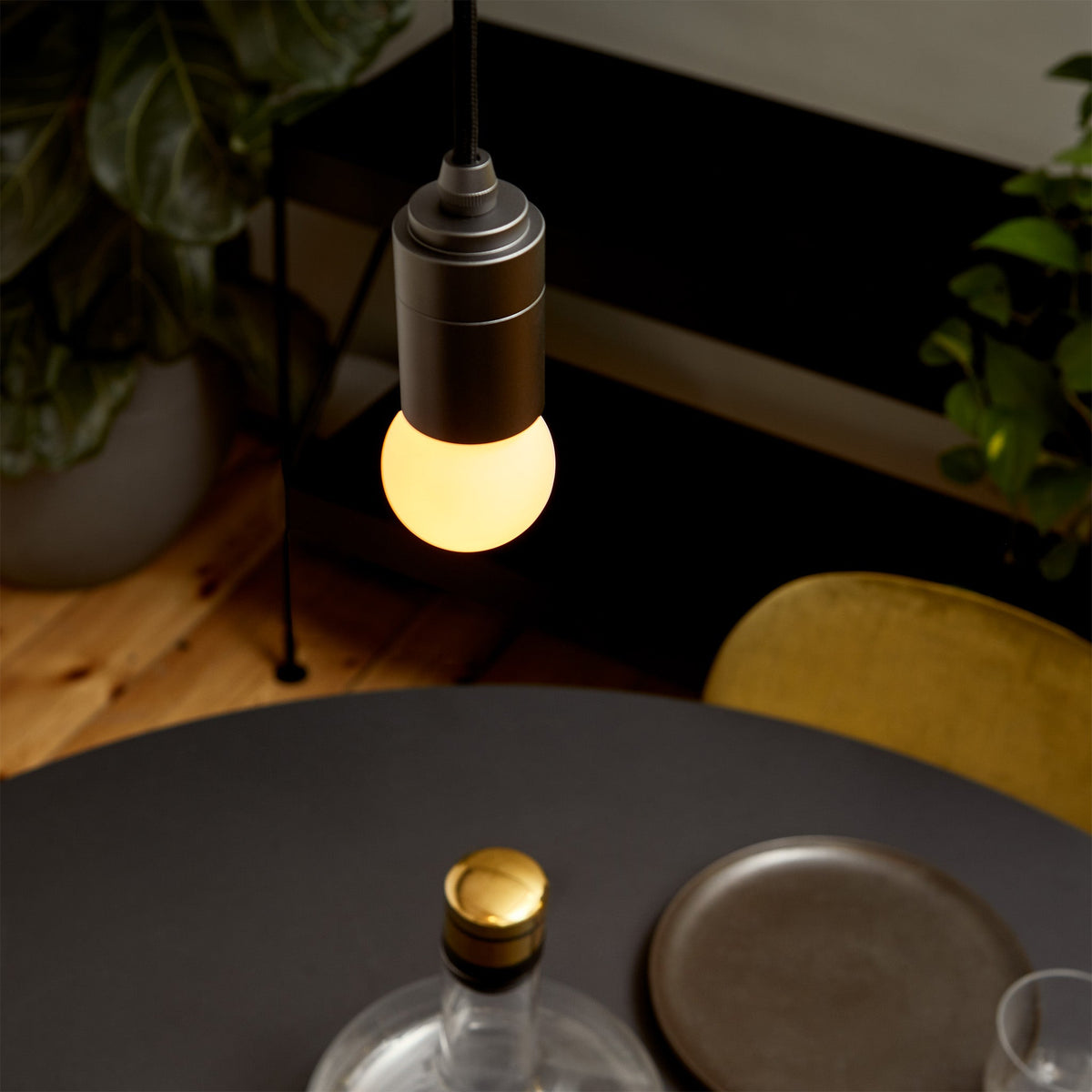 The Sphere I E26 Dim-to-Warm LED Bulb by Tala Lighting over a dining table.