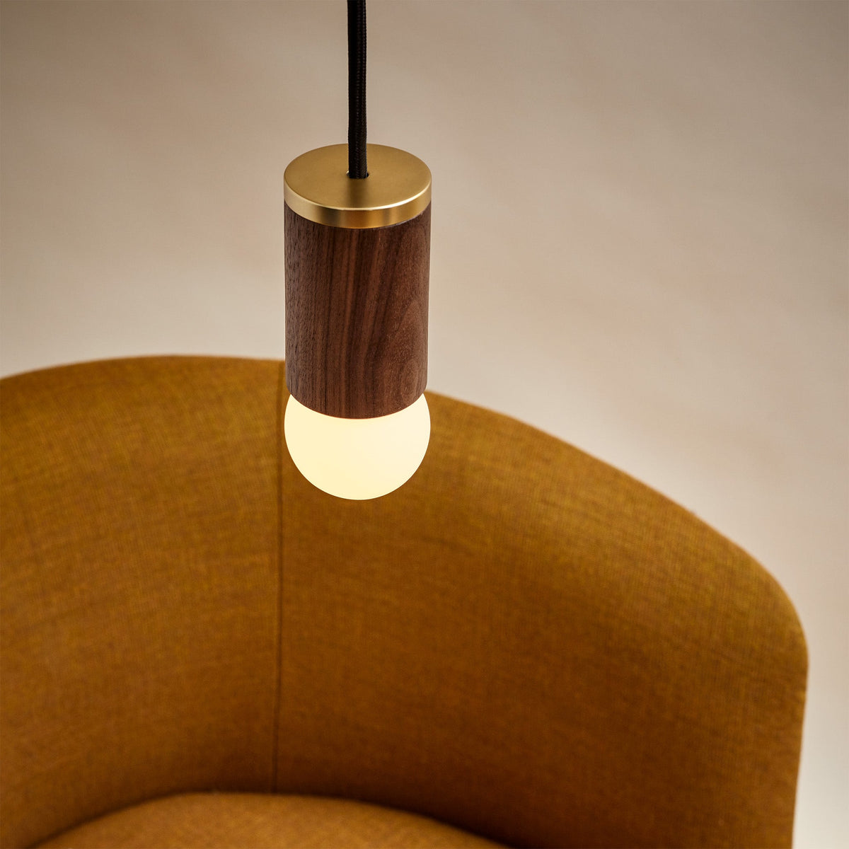 The Sphere I E26 Dim-to-Warm LED Bulb by Tala Lighting in a walnut pendant.