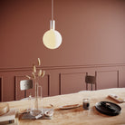 The Sphere V E26 Dim-to-Warm LED Bulb by Tala Lighting over a dining room table.