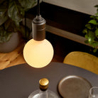 The Sphere III E26 Dim-to-Warm LED Bulb by Tala Lighting over a dining room table.