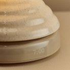 Detail of the pebble white ceramic base  with integrated clock of the Wake Sleep Light by Tala Lighting.