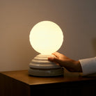 Hand controlling the turn control base of the Wake Sleep Light by Tala Lighting.