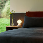 The Wake Sleep Light by Tala Lighting in pebble white on a nightstand.