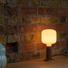 The Oblo E26 LED Bulb by Tala Lighting in a walnut knuckle table base.