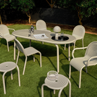 Outdoor Groove dining set in Putty by Tom Dixon on a garden.