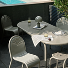 Outdoor Groove dining set in Putty by Tom Dixon on a pool patio.