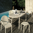 Outdoor Groove dining set in Putty by Tom Dixon on a pool deck. 