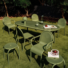 Outdoor Groove dining set in Moss by Tom Dixon in a garden.