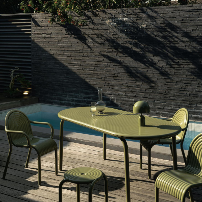 Outdoor Groove dining set in Moss by Tom Dixon on a deck.