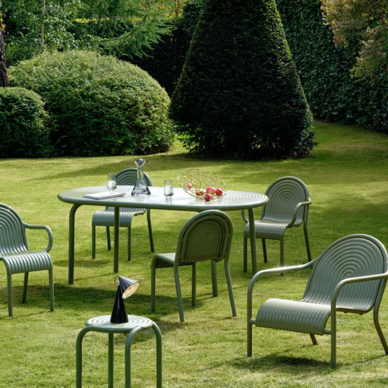 The Groove Outdoor Collection by Tom Dixon in Moss in a garden setting.