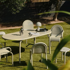 Outdoor Groove dining set in Putty by Tom Dixon in a garden.