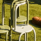 Stacked Groove stools and chairs on a lawn.