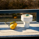 The Stone Portable Light by Tom Dixon in Brass on an outdoor table.