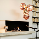 Tom Dixon Melt Chandelier Mini in Copper by a fireplace. all-groups