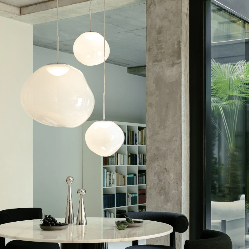 The Melt Mini Pendant and Medium Pendant from Tom Dixon in opal and silver over a dining table.
