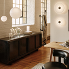 Tom Dixon Press Frosted Medium and Mini Sphere Pendants and Press Frosted surface mount sconces in a living room.