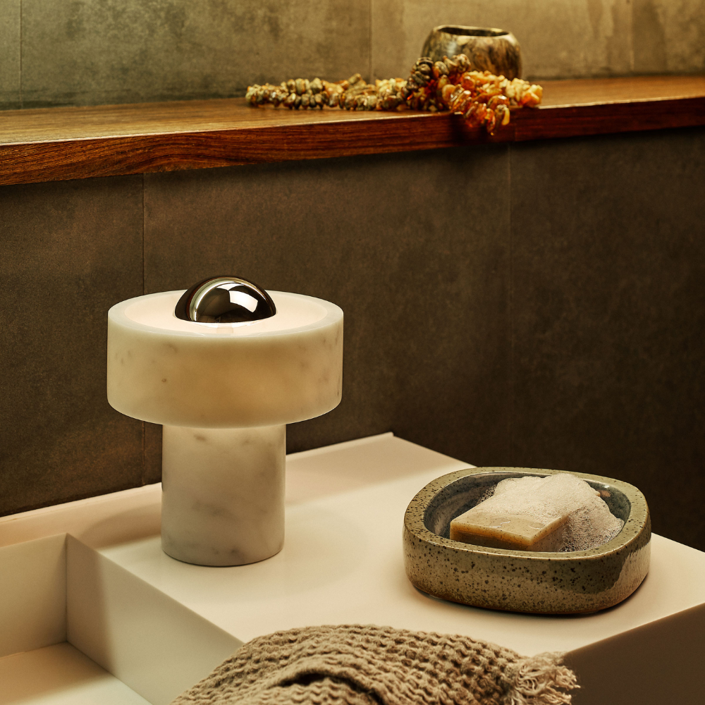 The Stone Portable Light by Tom Dixon in Silver in a bathroom.