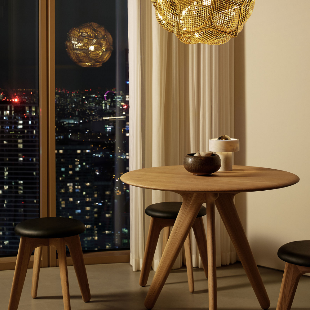 The Stone Portable Light by Tom Dixon in Brass on a dining table.