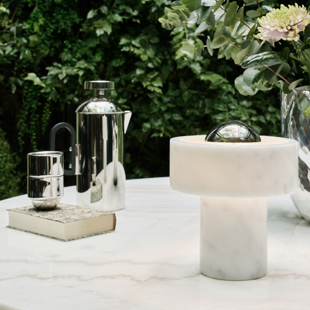 The Stone Portable Light by Tom Dixon in Silver on a table.