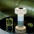 The Stone Portable Light by Tom Dixon in Brass on a cocktail table.