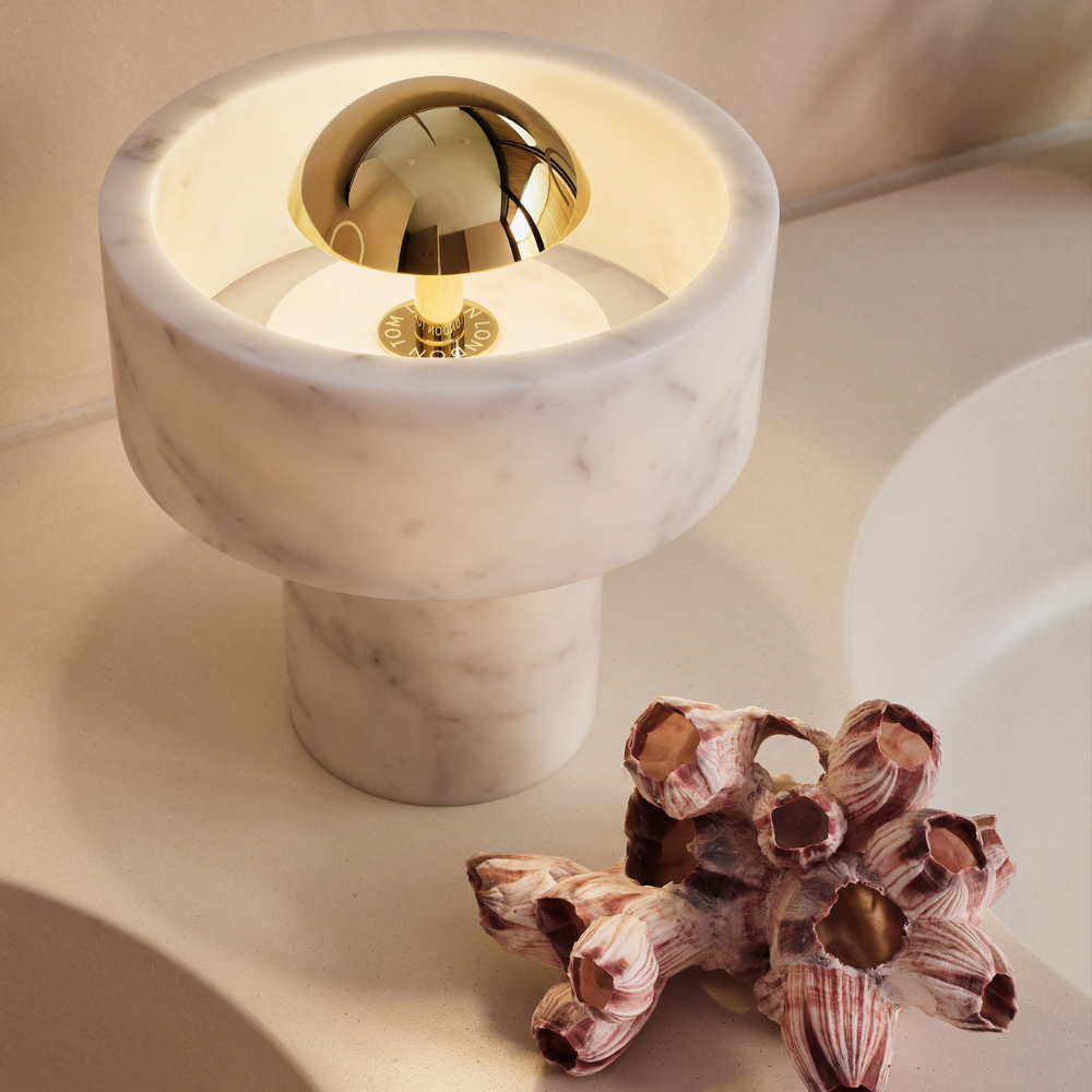 The Stone Portable Light by Tom Dixon in Brass on a bathroom vanity.